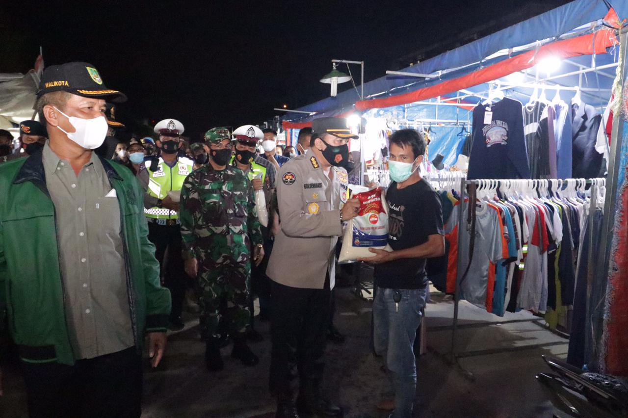 Patroli skala besar Polda Kepri dan jajaran membagikan bantuan paket sembako ke pedagang.