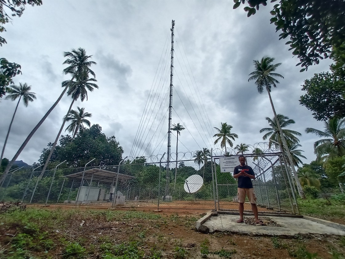 Seorang warga beraktivitas di dekat infrastruktur jaringan 4G USO yang dikelola XL Axiata di Desa Mekar Jaya, Bunguran Barat, Natuna, Senin (04/10/2021).