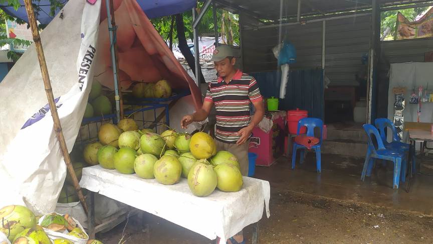 Penjual es kelapa di kawasan Batam Center, Batam, mengaku omzet penjualannya menurun akibat hujan beberapa hari ini.
