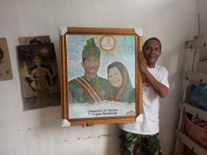 Yudha Marbun, penyandang disabilitas menunjukkan karya lukisnya.