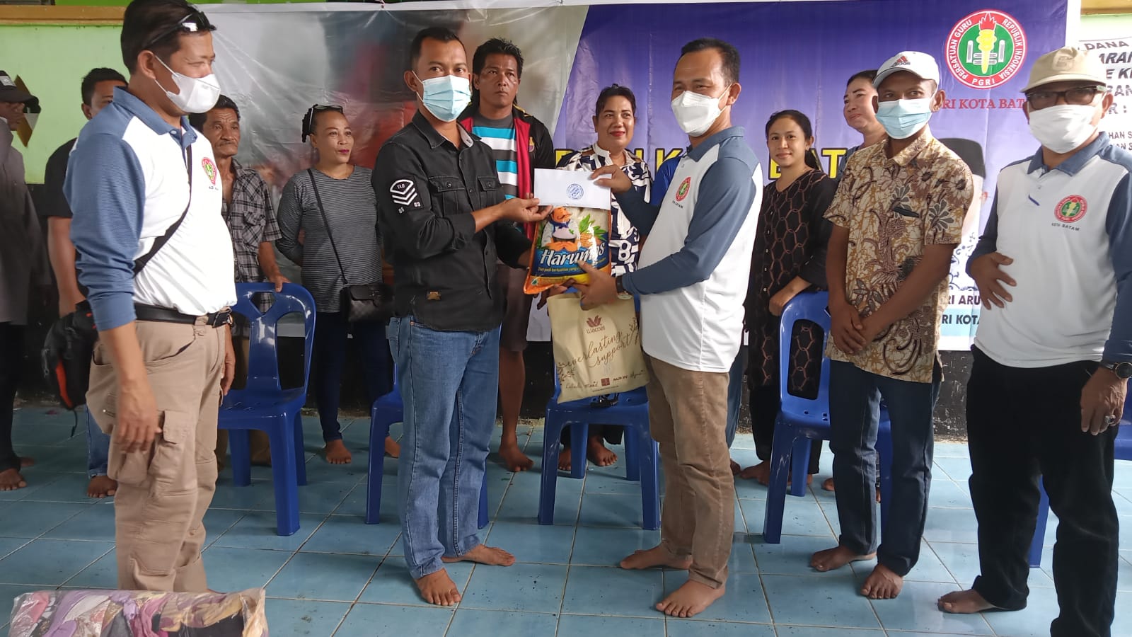 Ketua PGRI Batam, Hendri Arulan menyerahkan bantuan untuk korban kebakaran di Pulau Buluh