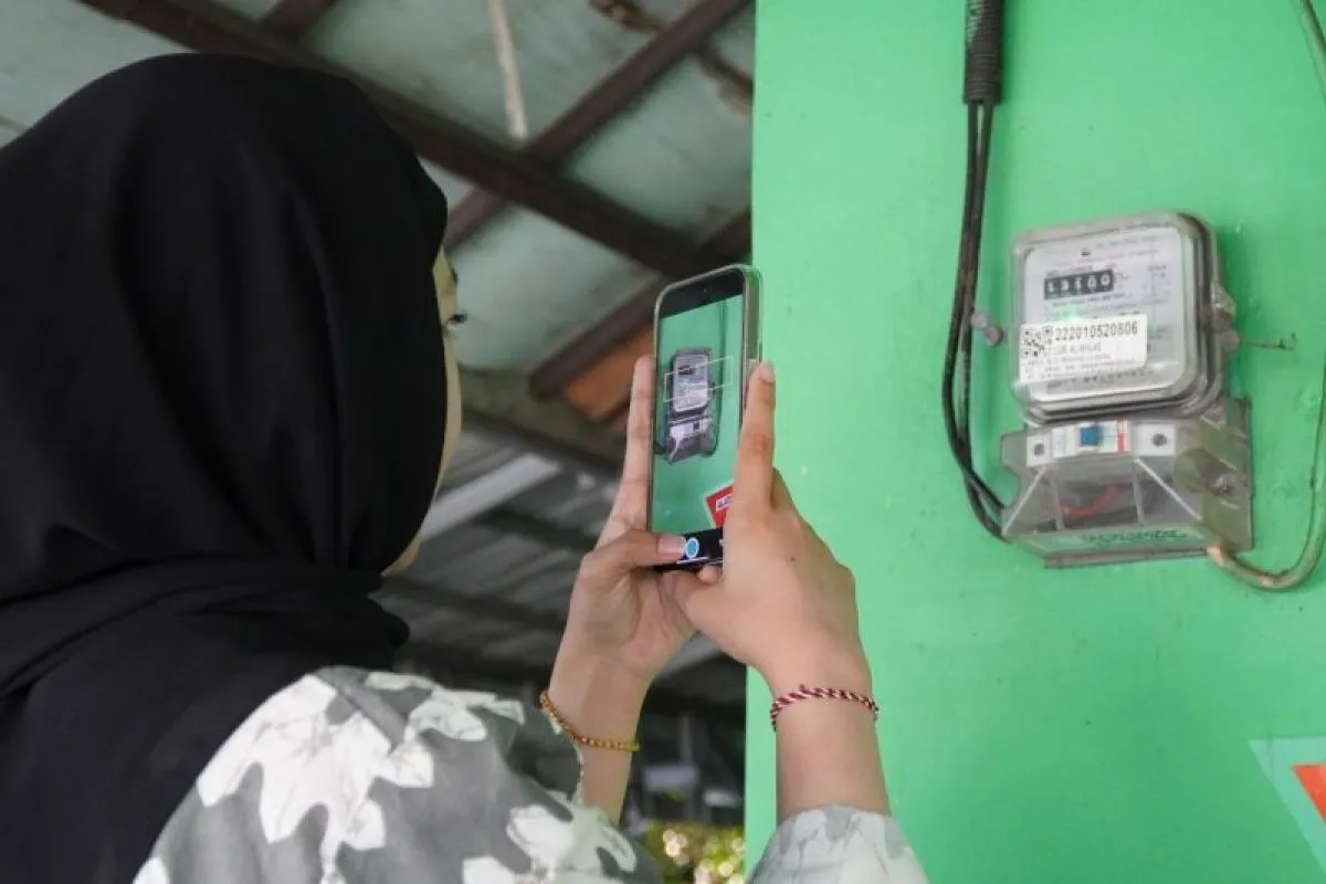 Petugas PLN memeriksa kWh meter listrik di rumah pelanggan di Batam.