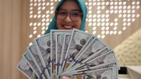 Petugas bank menghitung uang dollar AS terkait data cadangan devisa Indonesia yang turun pada Mei 2026.