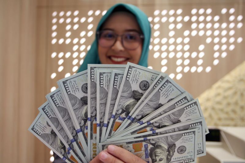 Petugas bank menghitung uang dollar AS terkait data cadangan devisa Indonesia yang turun pada Mei 2026.