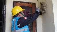 Teknisi memeriksa instalasi listrik rumah yang sedang dibangun.