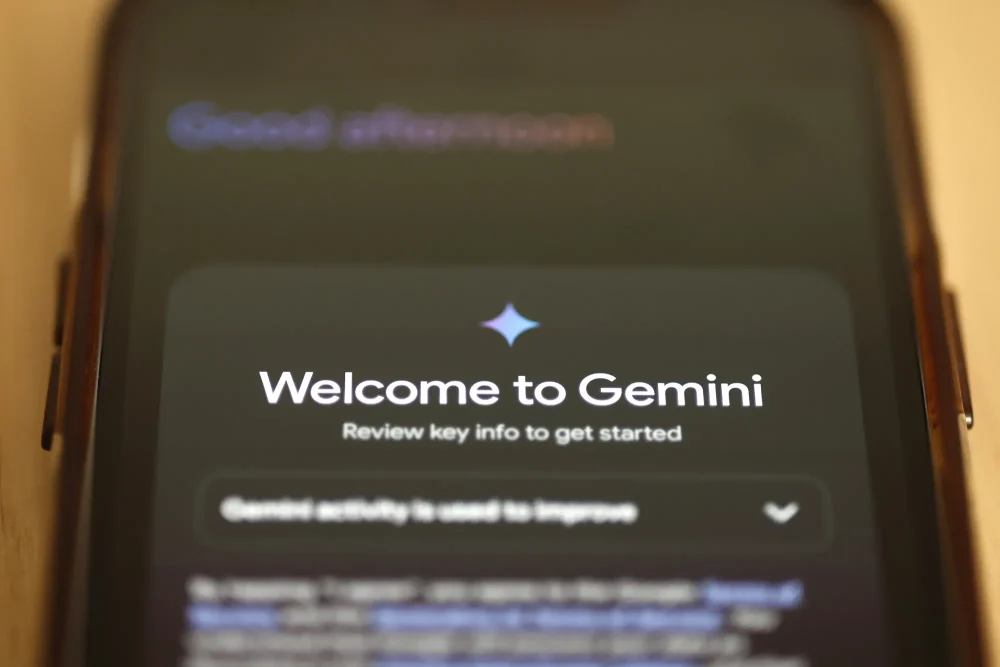 Ilustrasi seseorang menggunakan aplikasi Gemini di telepon seluler untuk membuat gambar berbasis AI.