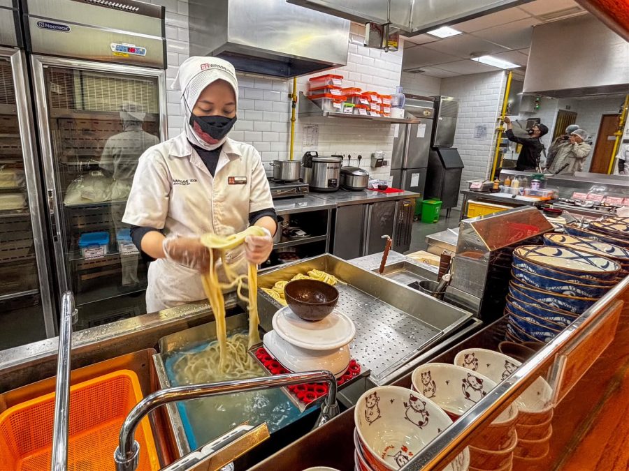 Teknisi PGN Gagas bersama staf Marugame Udon meninjau instalasi tabung silinder CNG berwarna kuning di area operasional restoran.